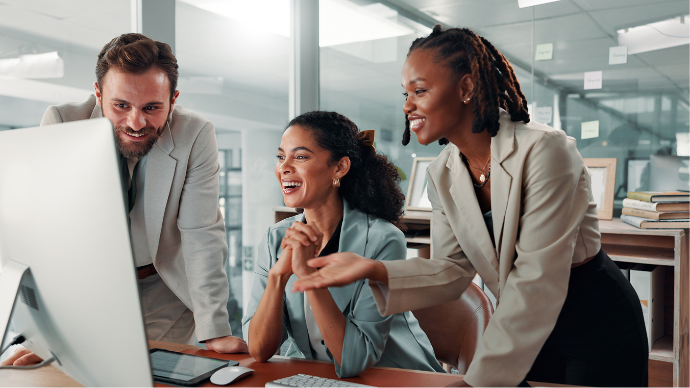 A collaborative team gathered around a laptop, working through a problem together